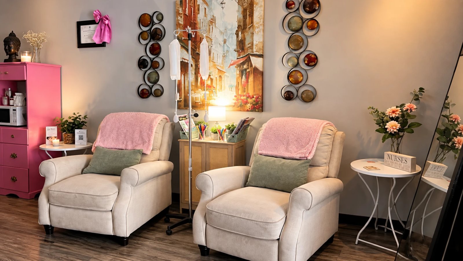 IV lounge with two cream recliners, pink throws and an IV stand